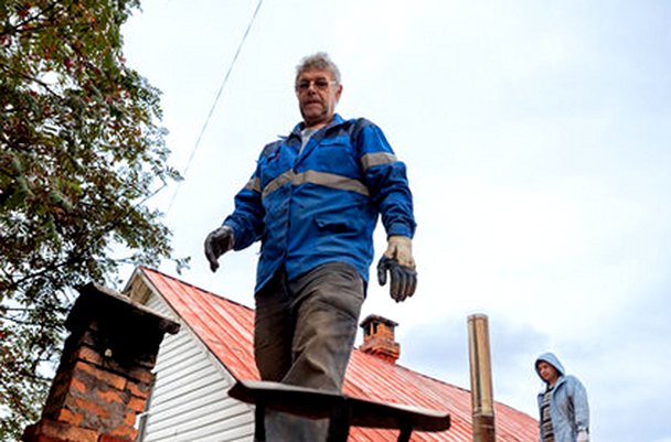 Two crewmen on a roof keeping watch over a chimney